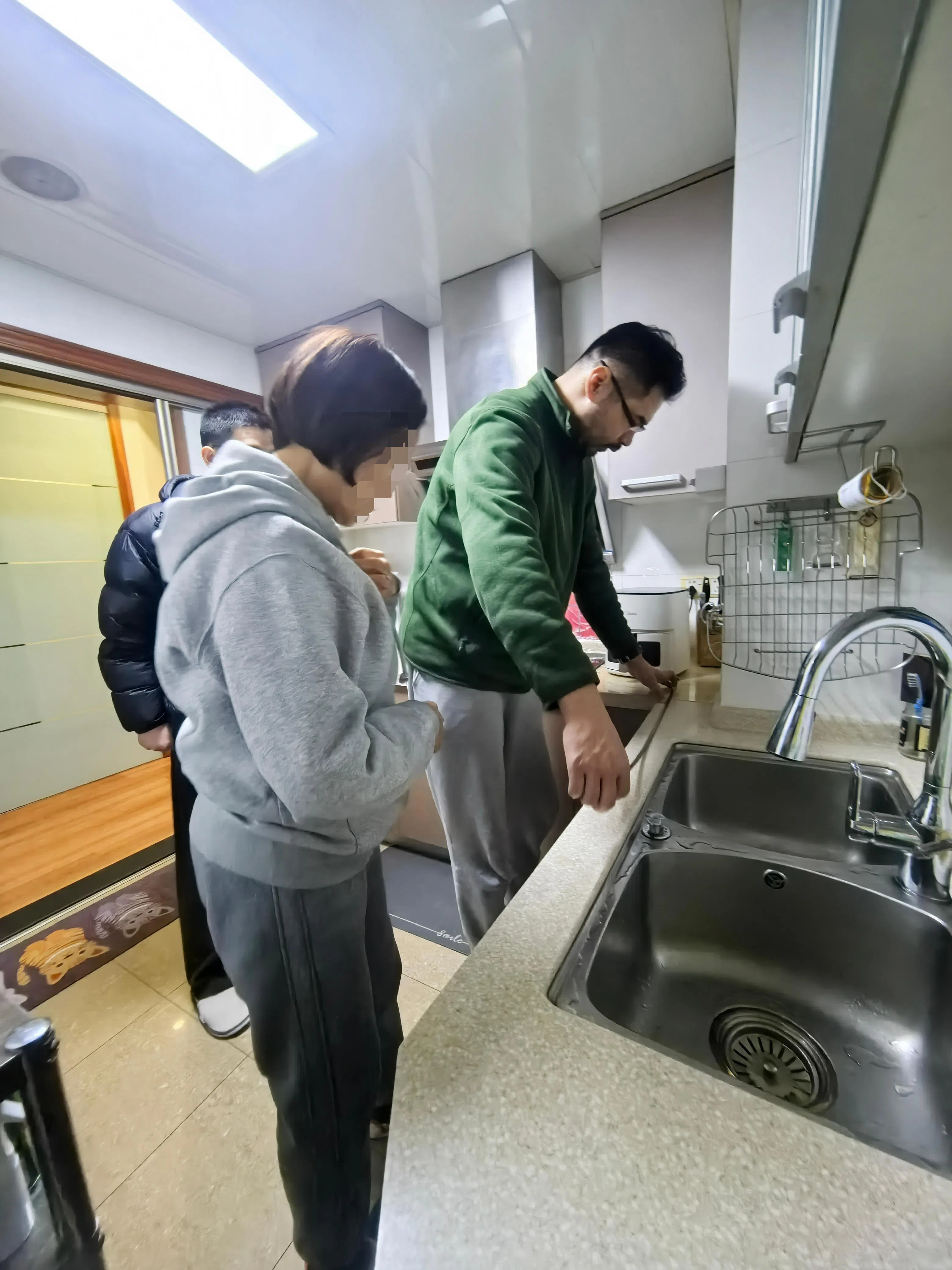 适老化改造设计师王晨（右）在客户家测量厨房操作台尺寸。（受访者提供）