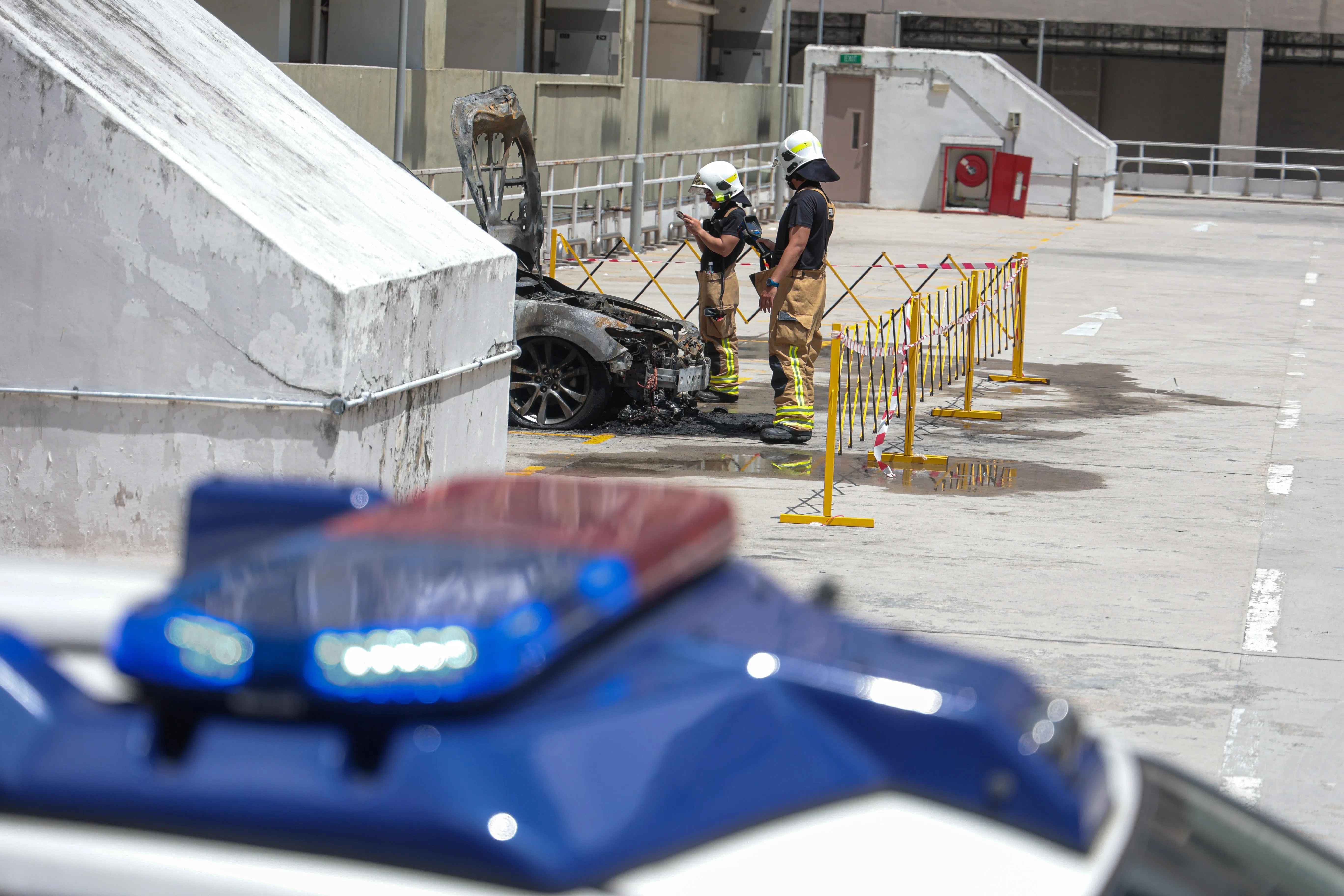 事发后，芳林熟食中心停车场顶层被封锁，直到中午才撤掉封锁线，但起火轿车周围仍被围起，以让民防部队人员继续调查失火原因。（李冠卫摄）