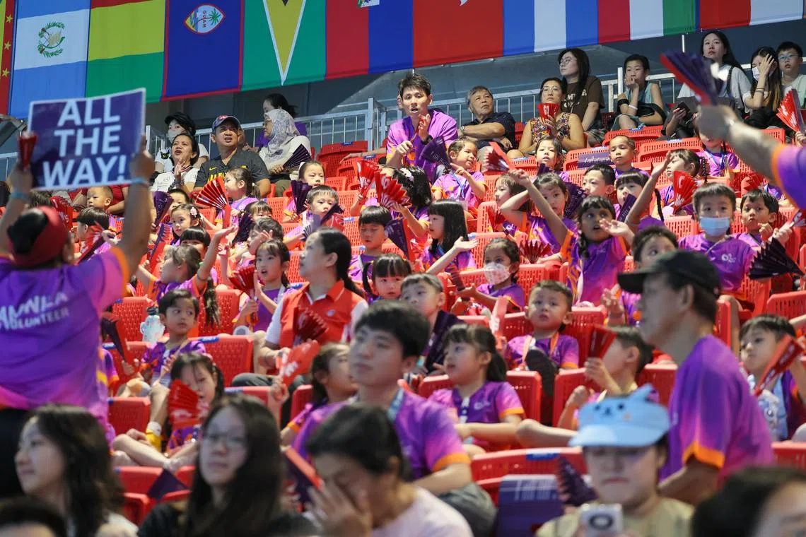 小尼拉跟随着志愿者的指令，随节奏一同为运动员加油。（张俊杰摄）