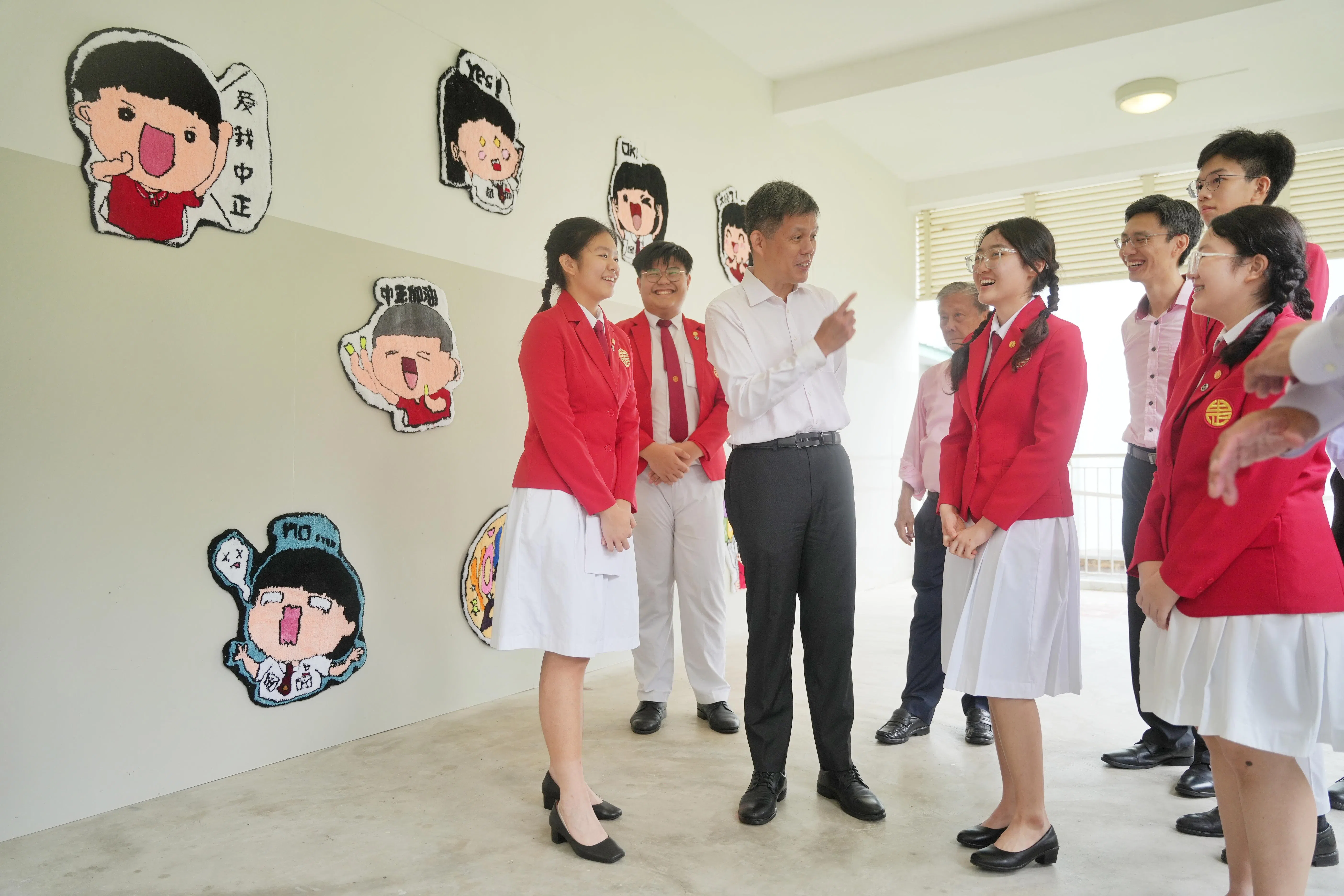 配合校庆，中正总校的教师制作了这些簇绒手工艺品。灵感来自学生所设计的逗趣贴纸，反映学校价值观和口号。学生领袖向教育部长陈振声做介绍，在场的包括中正董事会副主席许仁美博士（学生后方，左起）和中正总校校长姚至轩。（谢智扬摄）