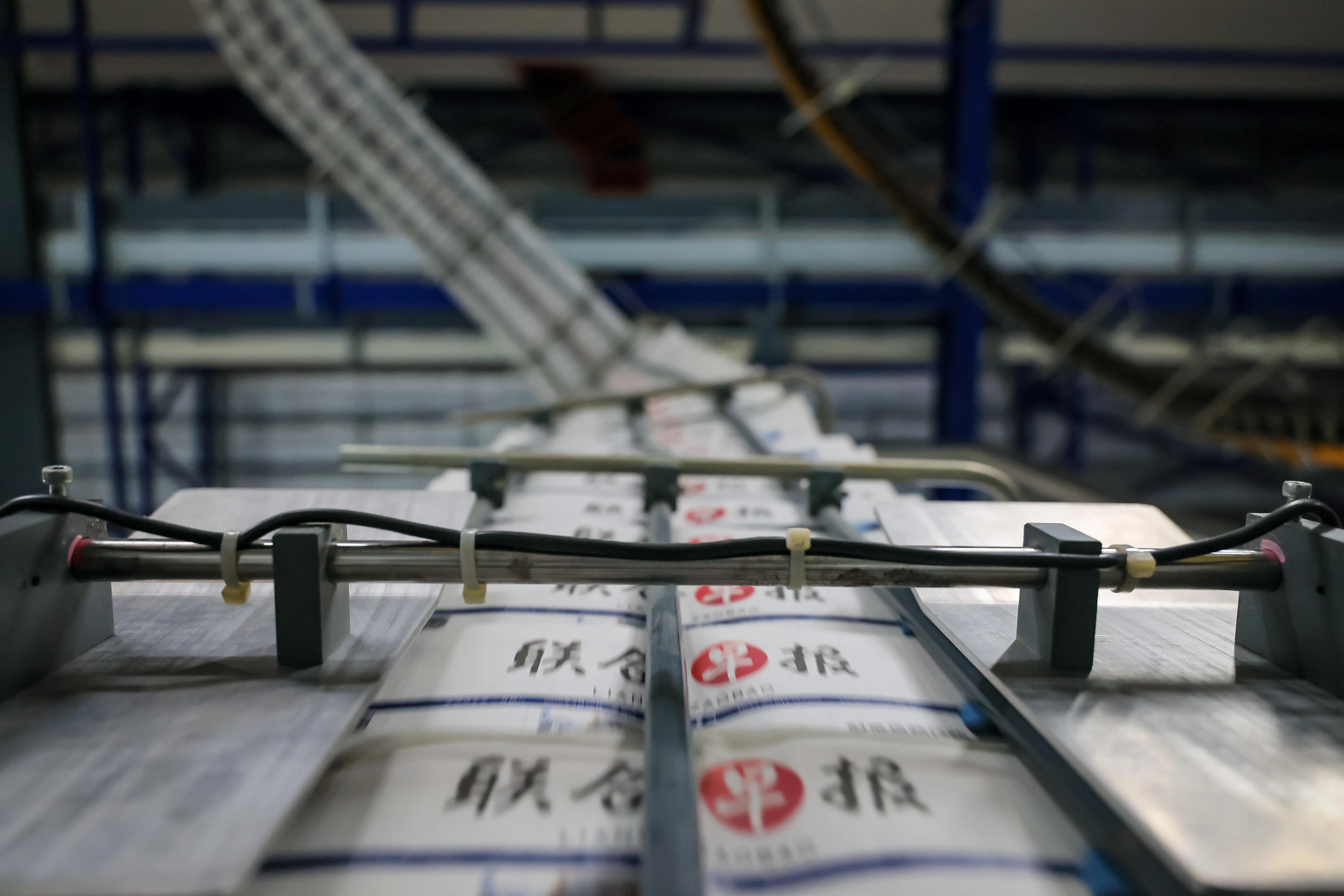 这画面乍看像微观世界的行人天桥，横跨在历史洪流中砥砺前行的《联合早报》。（龙国雄摄）