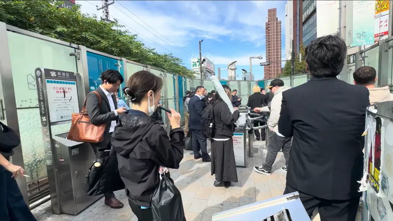 在日本的吸烟区可以看到许多烟客吸食电子烟。（截视频图）