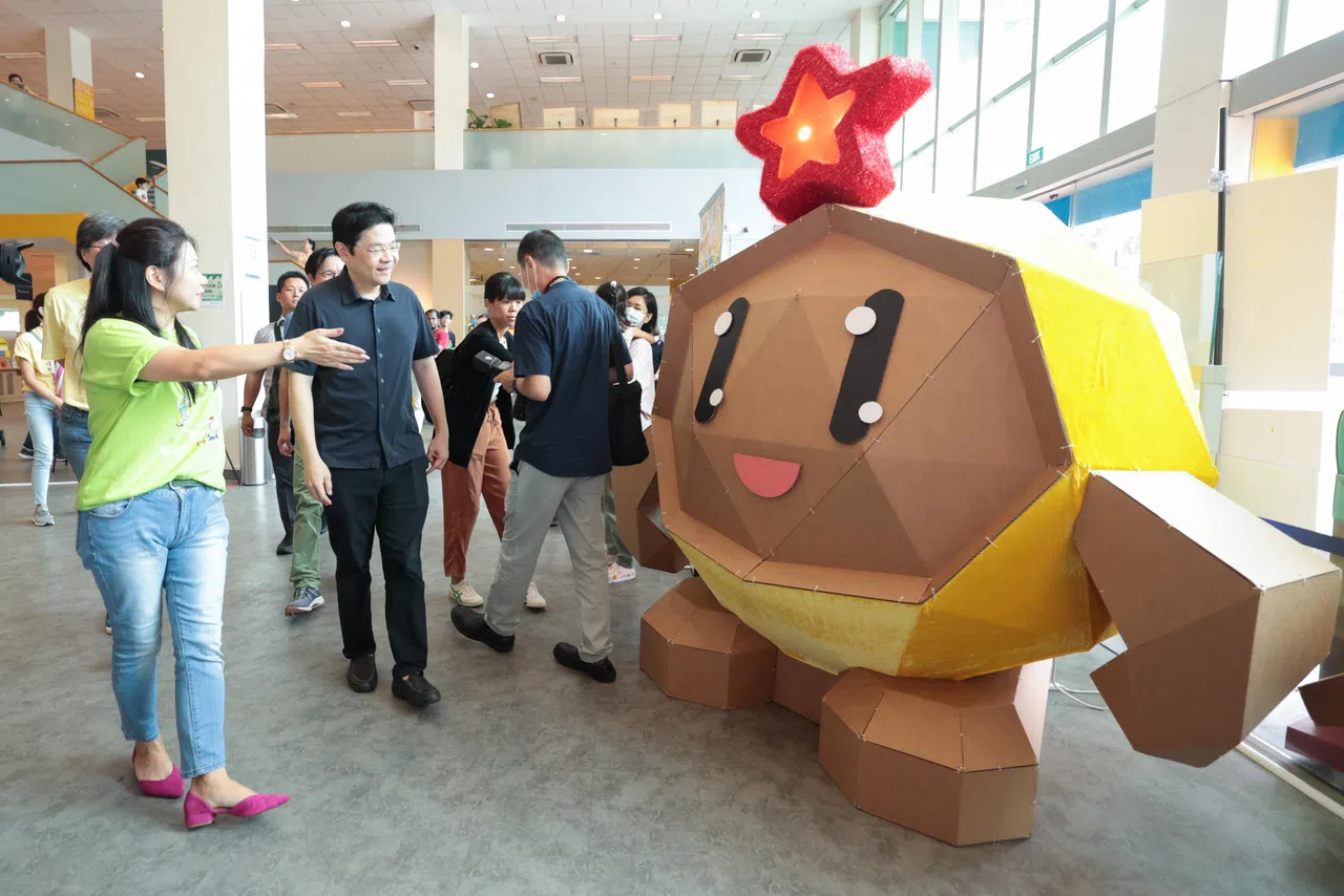 副总理兼财政部长黄循财（左二）星期天（6月4日）在宏茂桥公共图书馆参观《小小拇指》巡回展。早报校园主编杨漾（左一）在旁介绍。（李冠卫摄）