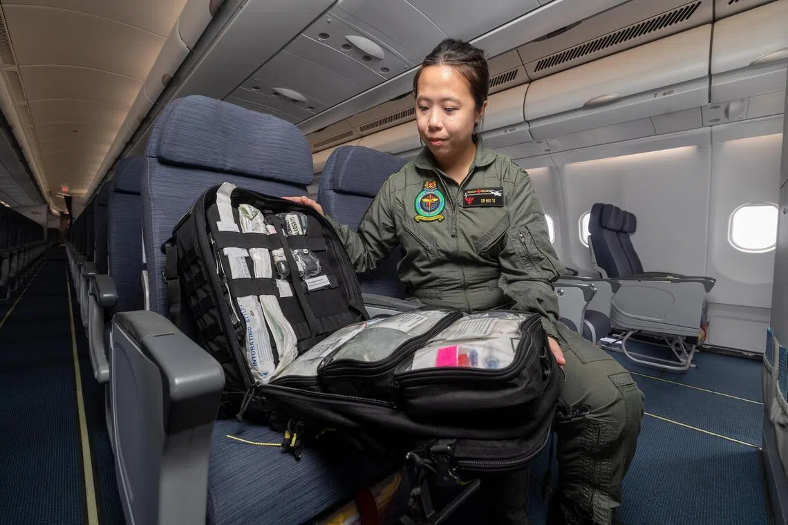 空军医务中队军医谢慧怡上尉在撤侨航班上为乘客提供医疗支援。她在国防部于3月27日安排的媒体访问中，展示装满药品的机上医疗包。（吴先邦摄）