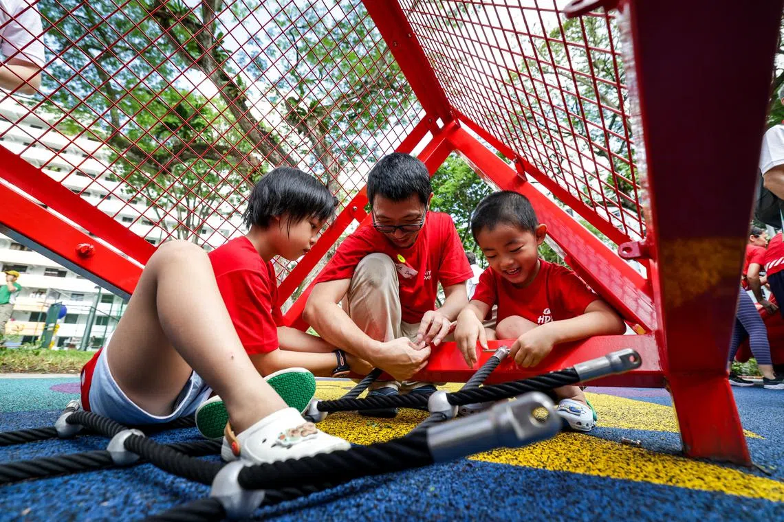 大巴窑的新溪蟹游乐场开幕当天，家长与孩子一同为新设施进行最后的小装置。（叶振忠摄）