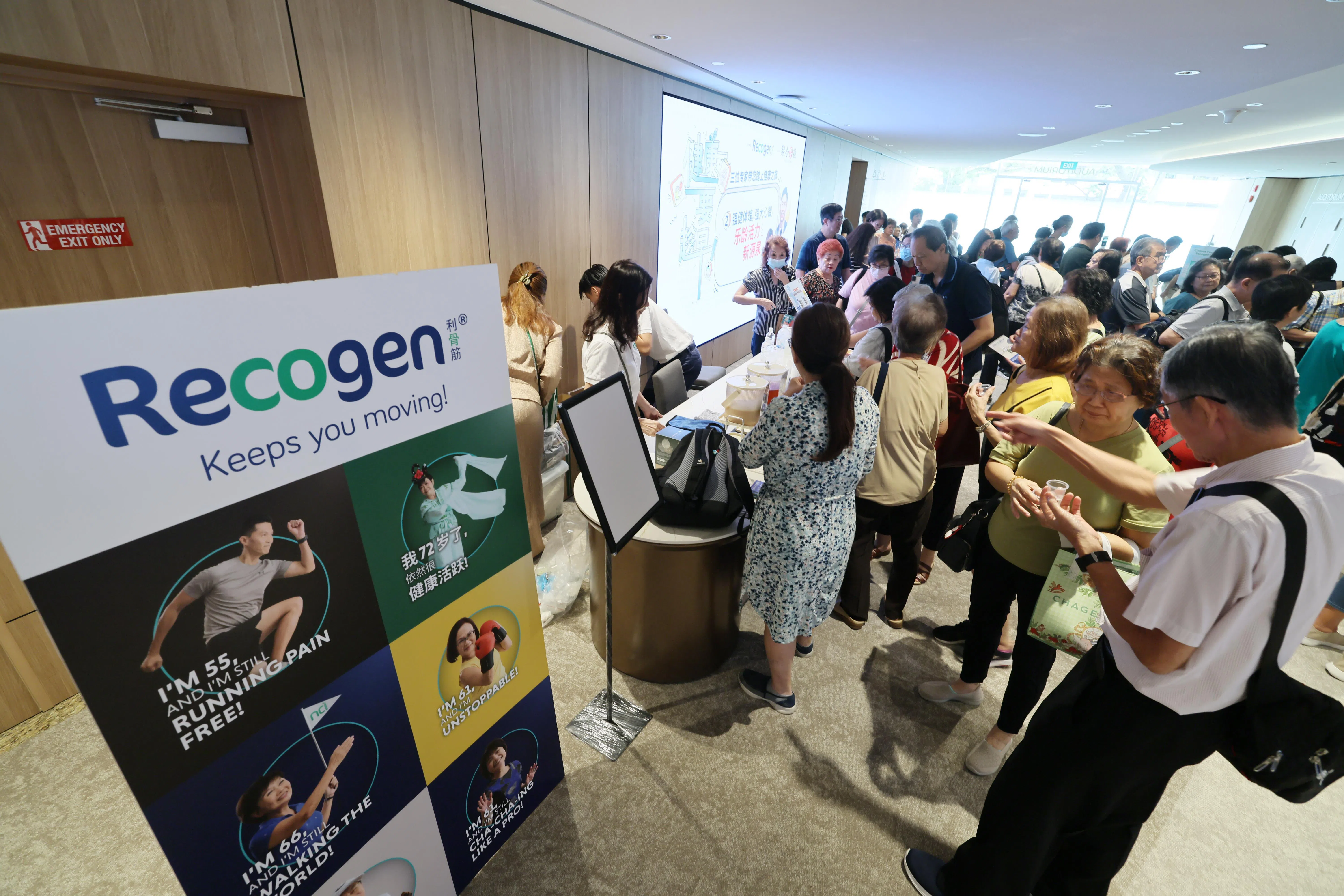 讲座开始前，报业中心礼堂外的保健摊位吸引读者试喝利骨筋产品。（龙国雄摄）