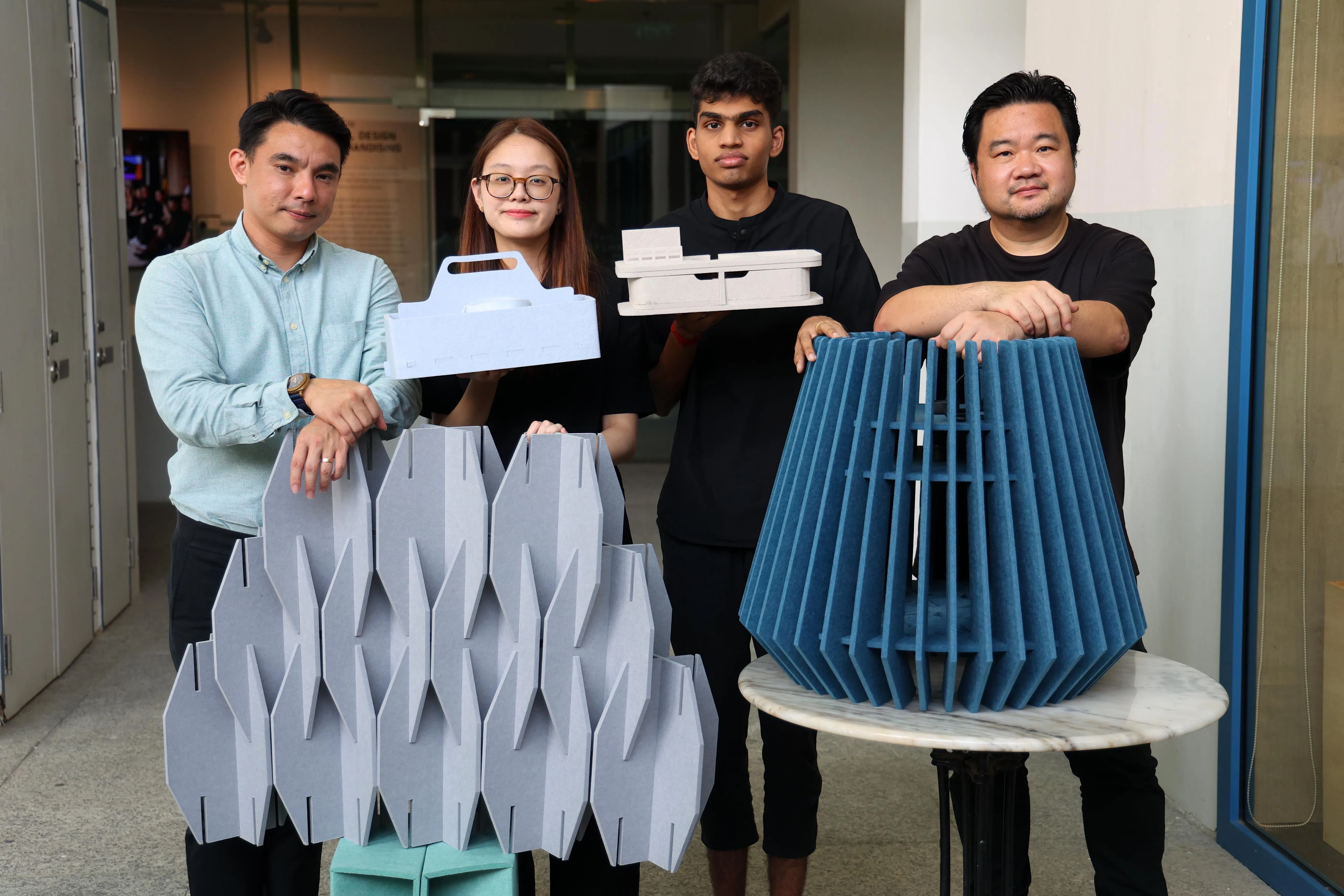 吸音板及墙纸供应商Pepperwall联合创办人叶俊杰（左一）希望，把多余的材料“再造”为其他产品，以减少垃圾，支持环保工作。淡马锡理工学院学生朱欣仪（左二）和尤咖（左三）在Pepperwall产品设计师黄得胜（右）的指导下，设计桌灯、抽屉等家居用品。（林明顺摄）