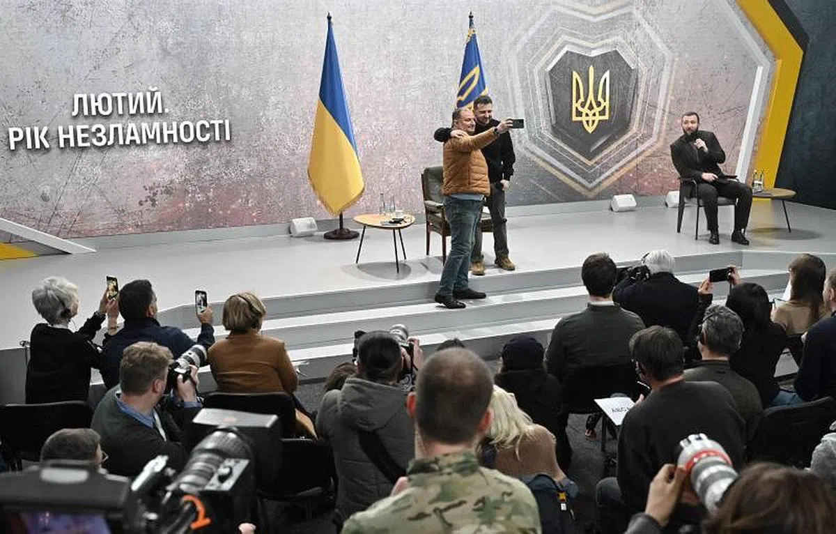 在2月24日的记者会上，泽连斯基和一名记者合拍自拍照。（法新社）