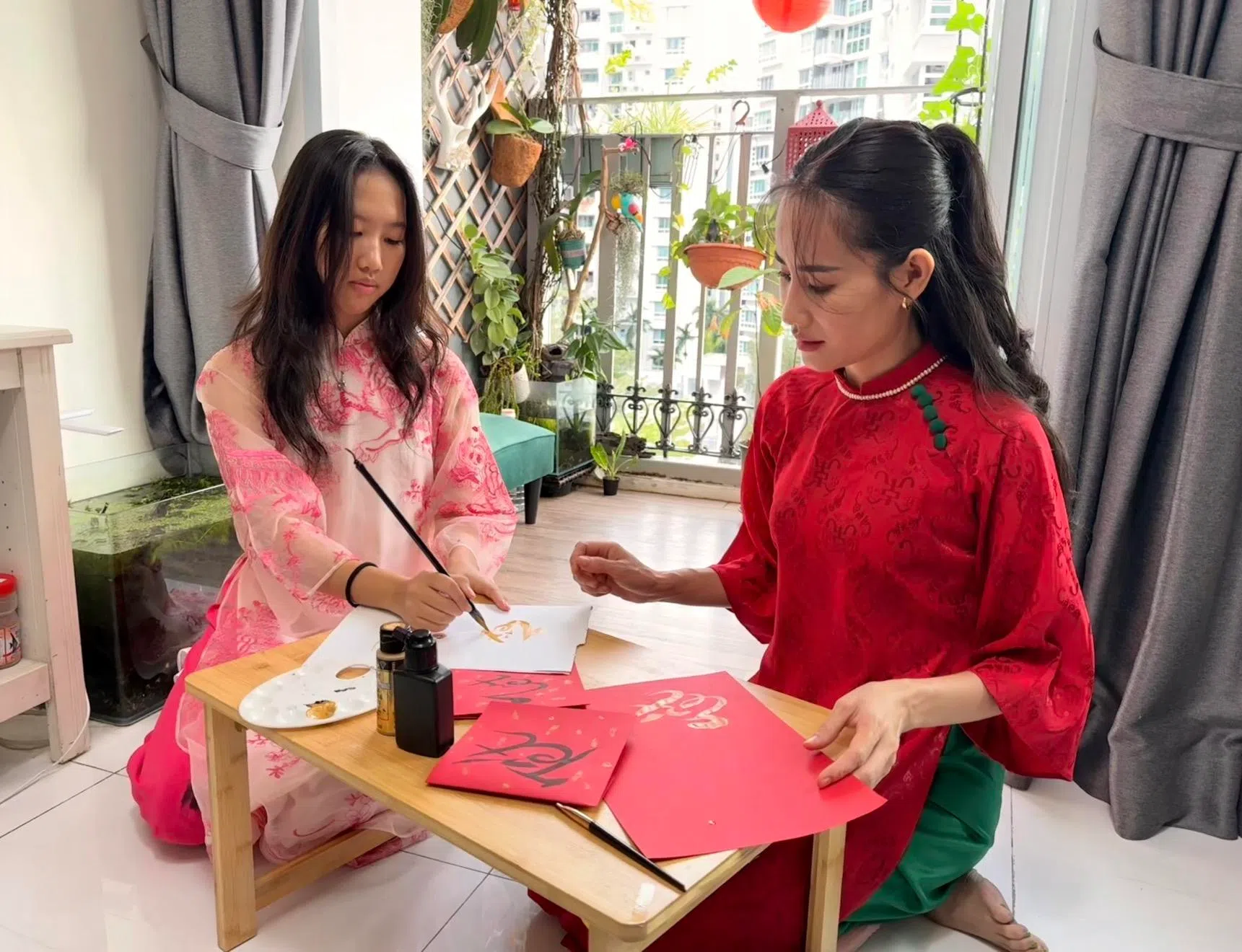 阮燕香教导女儿用越南罗马字（chữ Quốc ngữ）写越南文字春联。（萧康达摄）