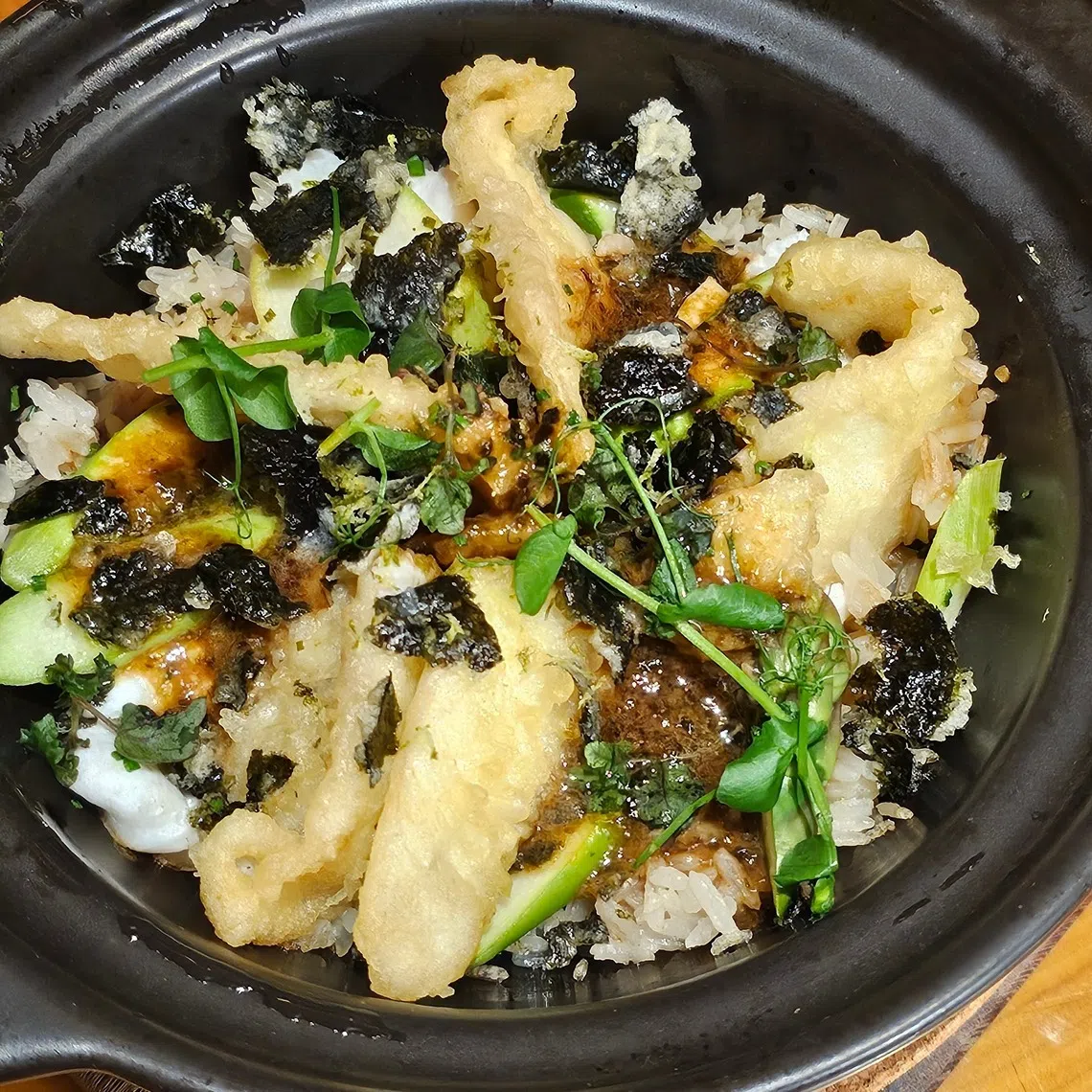 海鲜土锅饭里有蒸鱼和炸鱼两种做法和口味，味道更具层次。（黄亿敏摄）