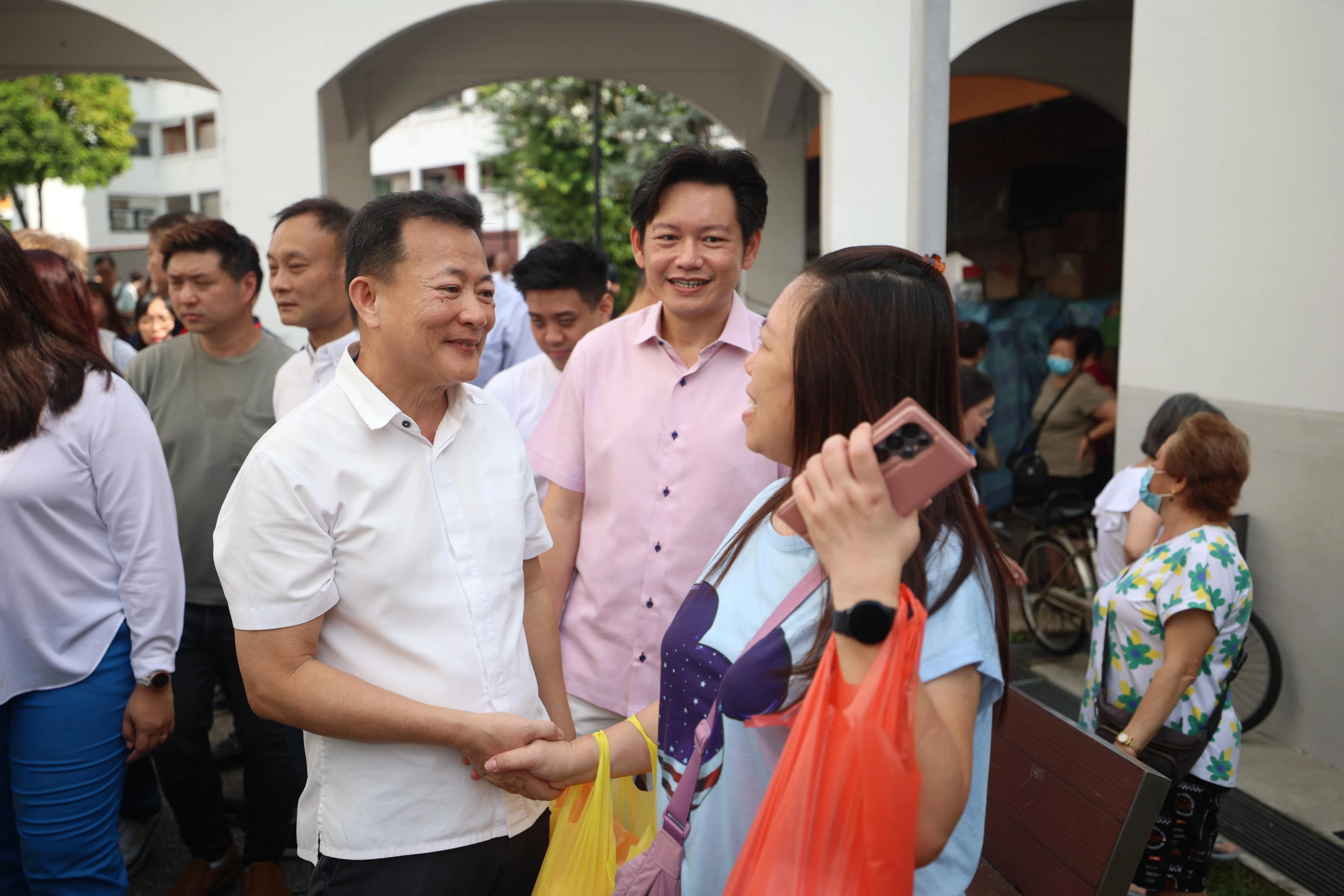 赖添发随李资政在后港一带走访居民。他说，自己的童年时住在宏茂桥，除了在阿裕尼集选区服务了差不多25年了，也常来到后港一带的巴刹走动。（关俊威摄）