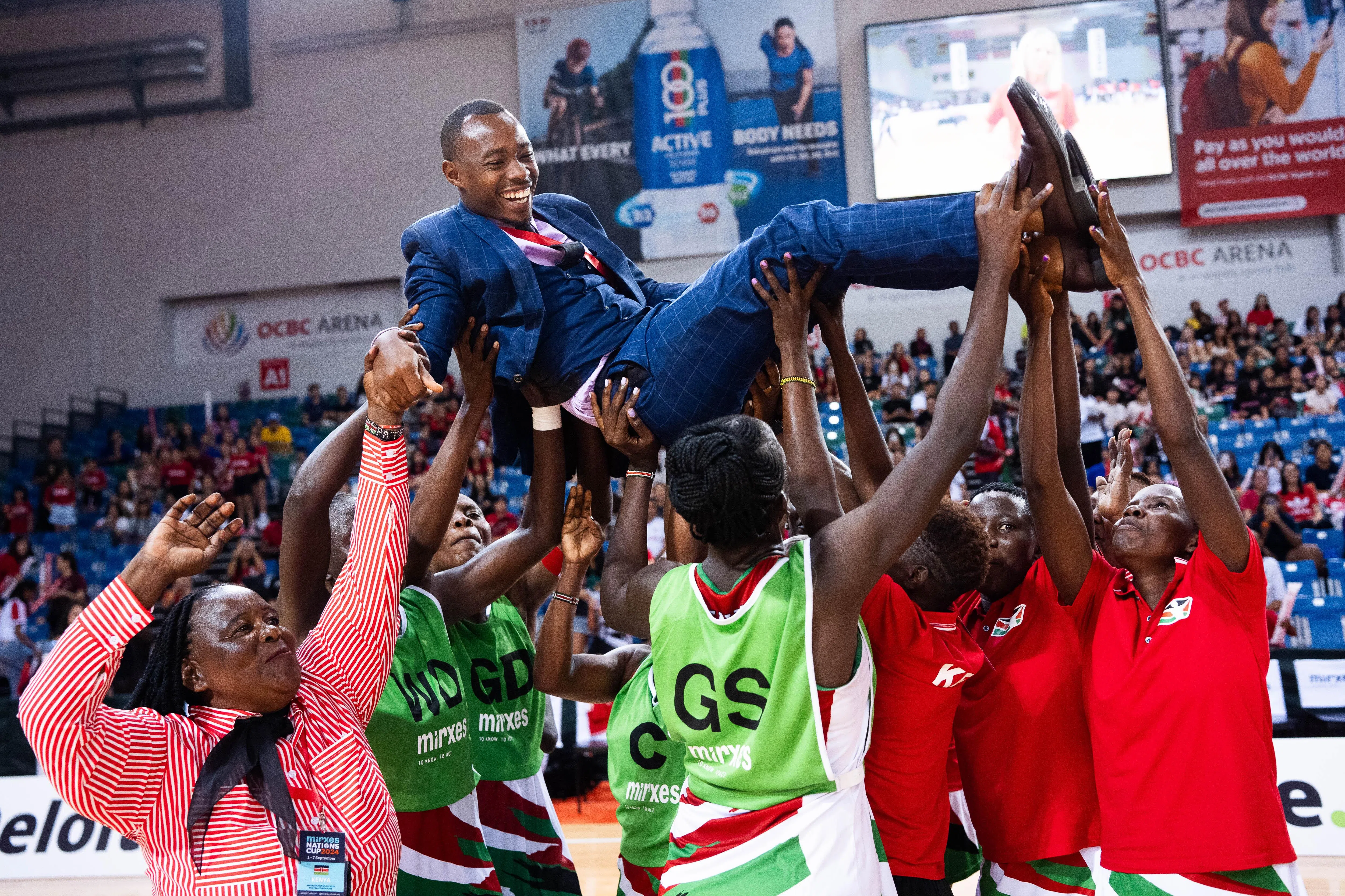 肯尼亚球员赛后将主帅穆吉沙抛起，庆祝夺冠。（新加坡英式女篮总会提供）