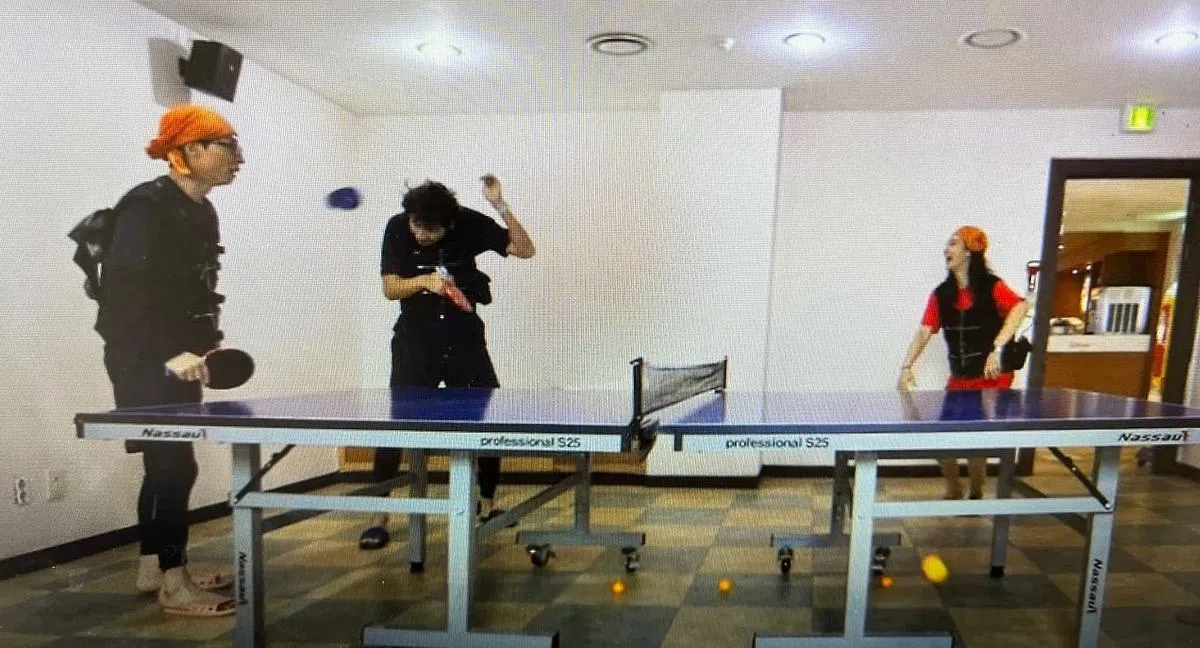 权俞利（右）拼命完成任务，刘在锡（左）和李光洙（中）却在偷懒打乒乓，她气得拿起拖鞋扔向他们。（视频截图）