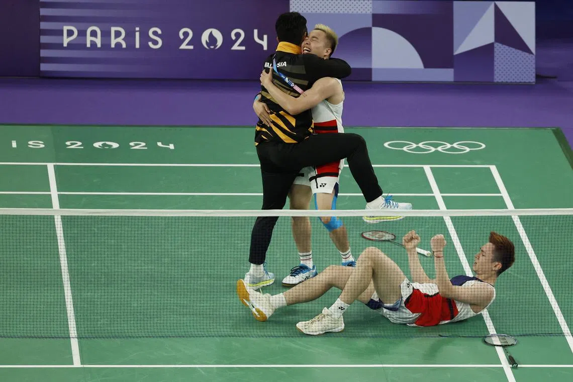 艰难赢得铜牌的谢定峰（中）和苏伟译（下）获得铜牌后和教练一起庆祝。（路透社）