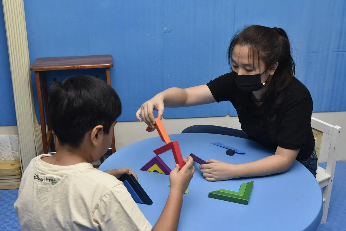作为职业治疗师助理，洪莞莹协助孩童完成各个活动项目，训练他们的手脚协调、平衡感等多方面的基本及高级动作技能。（伍书永摄）