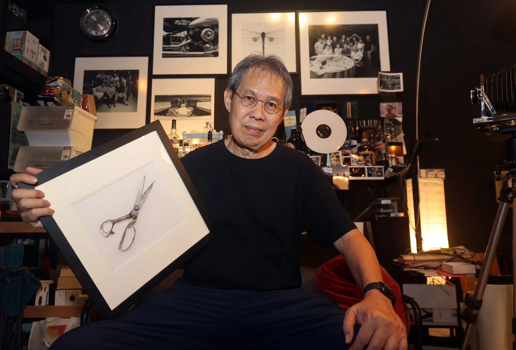 李德贤展示他亲手冲洗、拍摄的得意之作。（萧紫薇摄）