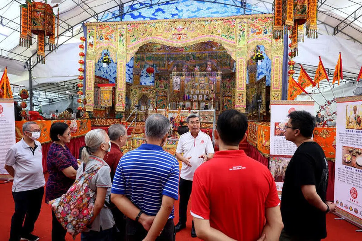 老字号绣庄“翁展发”第三代翁泽峰（面对镜头者），向导览团公众讲解潮绣之美。（龙国雄摄）