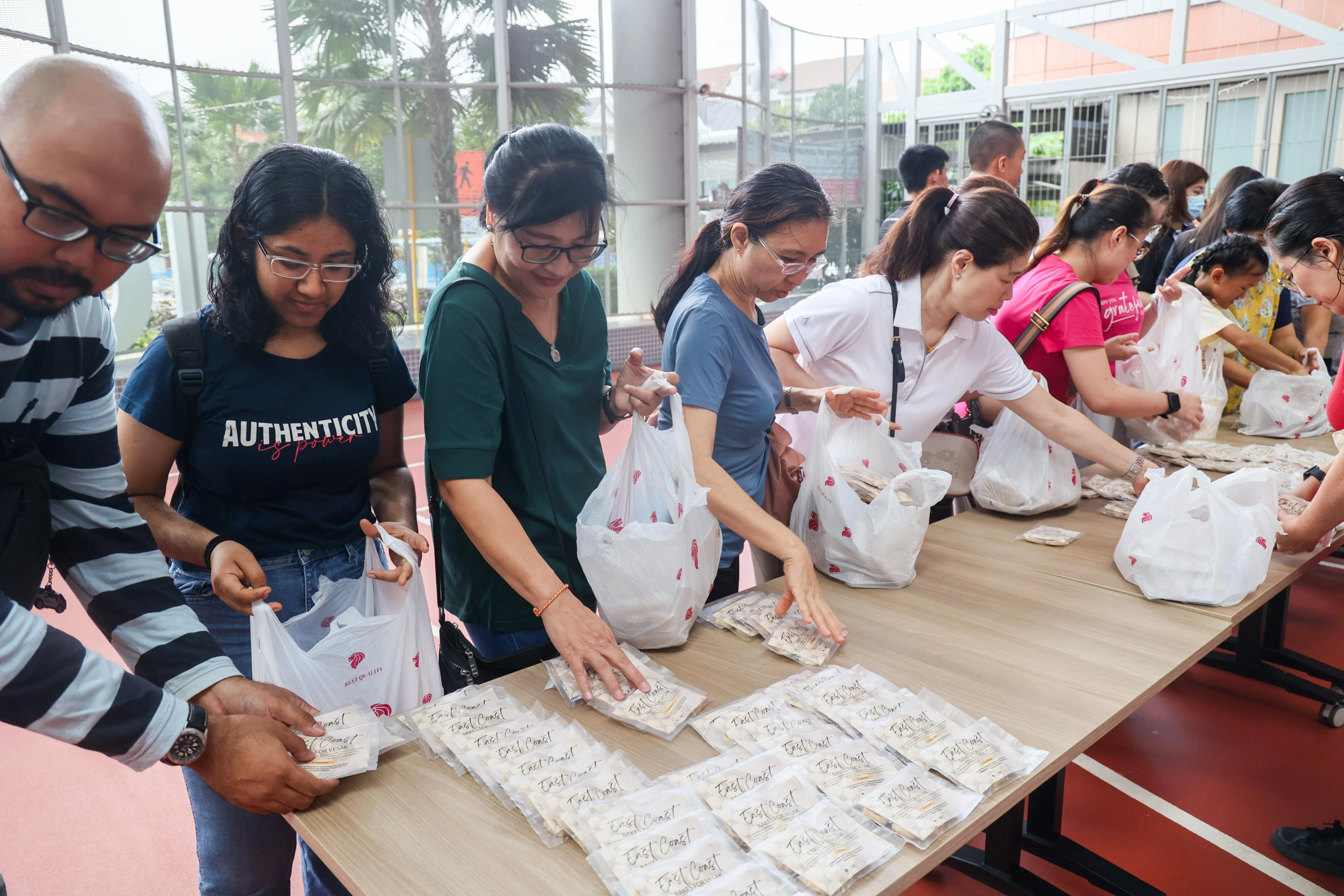 60多名志愿者将饼干装袋，准备到巴礼莱佛教寺和万佛林分发。（卓祾祎摄）