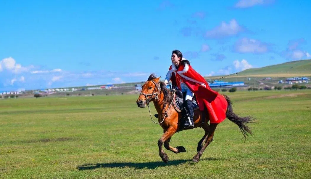 卢姿卉身披披肩，在呼伦贝尔大草原策马奔腾。（受访者提供）