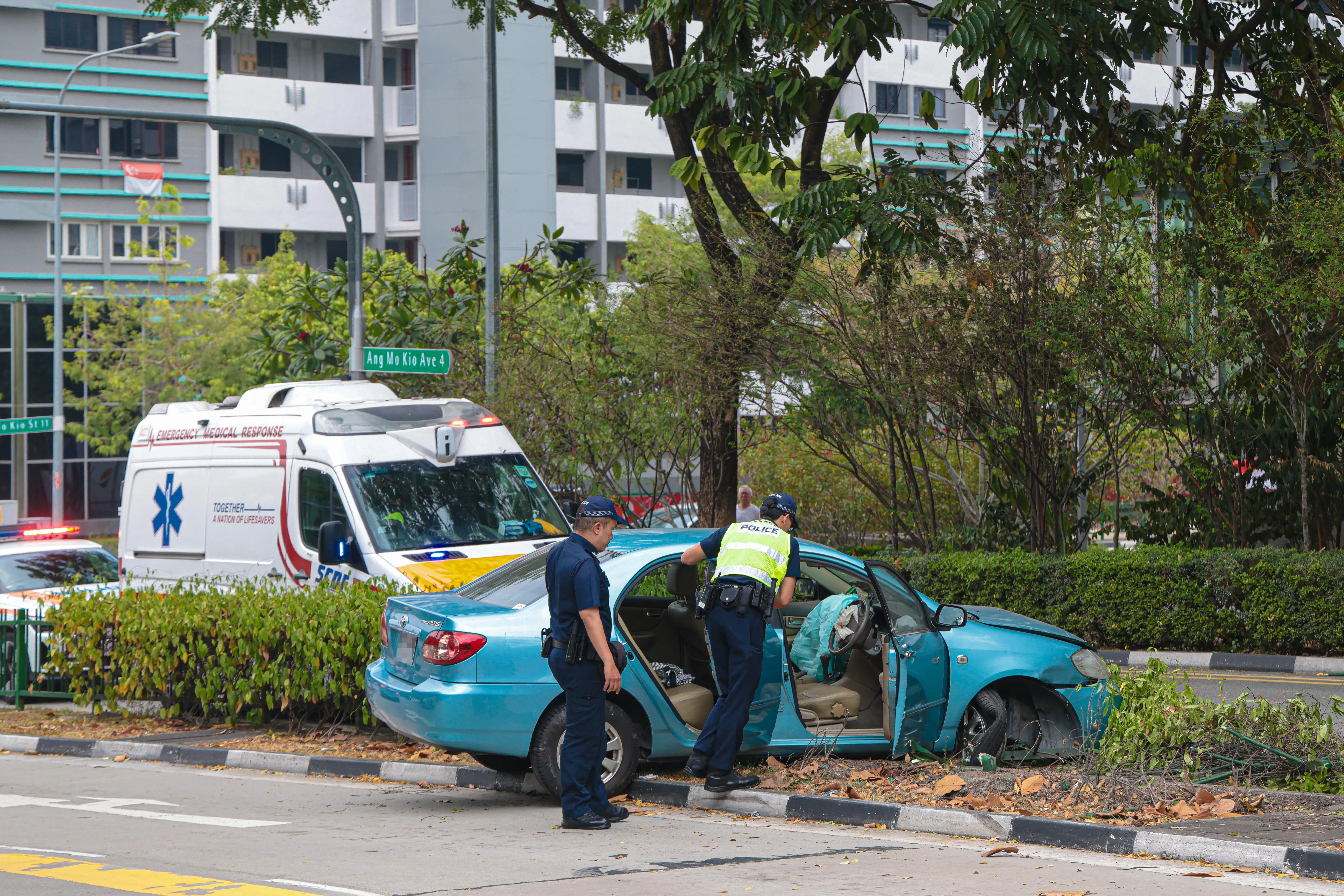 现场有至少两名交警、一辆警车和一辆警用电单车，交警在场指挥交通并检查车内情况。（李冠卫摄）