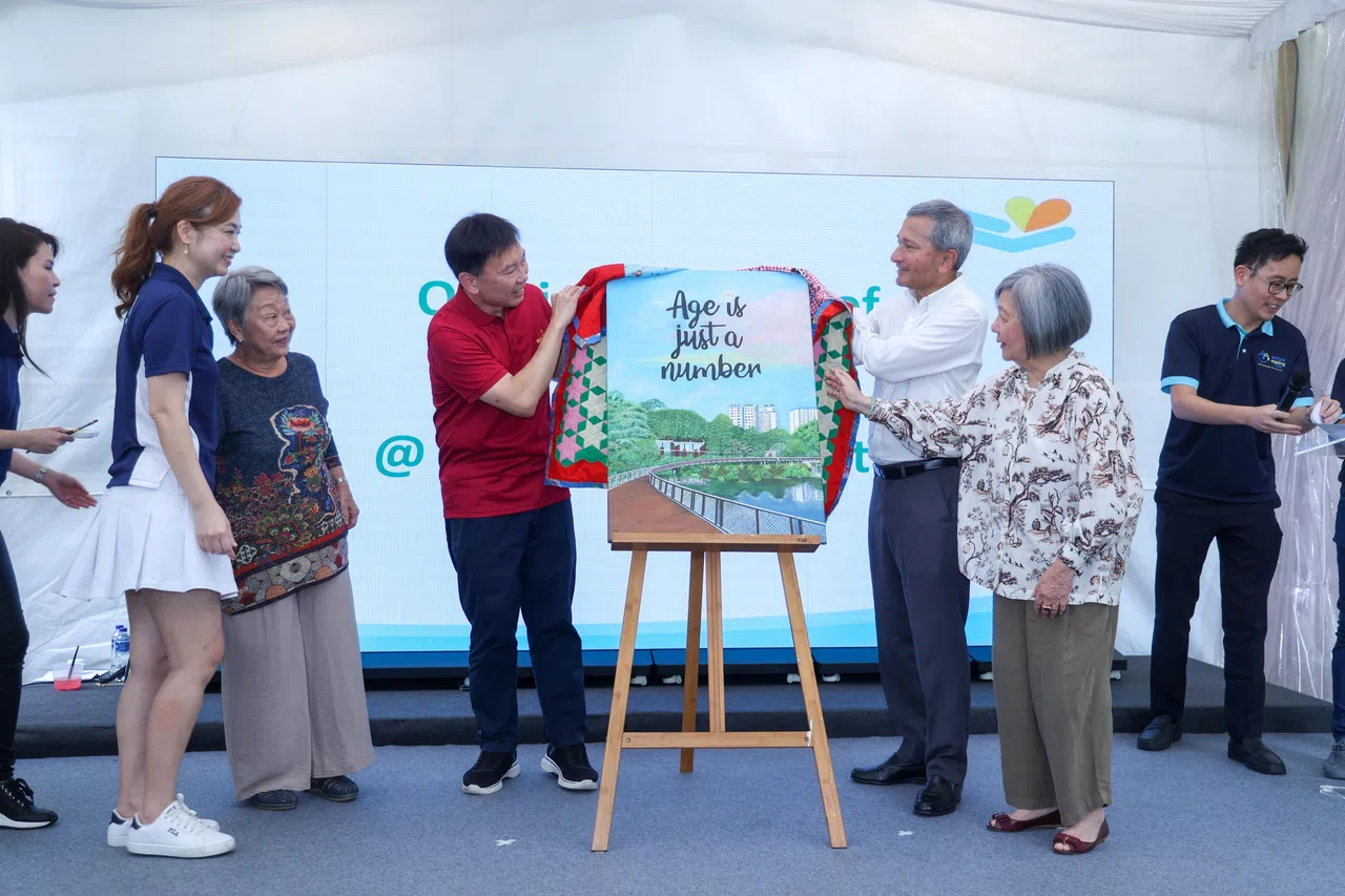 外交部长维文医生（右三）和交通部长兼财政部第二部长徐芳达（左三）一起掀开画作，宣布先锋活跃乐龄中心@3G Wellness Centre正式开幕。见证者是先锋保健集团总裁曾伟玲（左起）、年长者陈颤如，以及先锋保健集团主席蔡琼莹。（吴先邦摄）