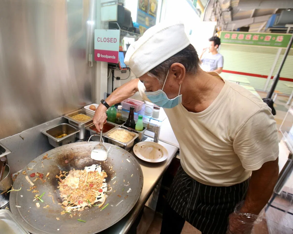 小贩等餐饮工作人员在处理食物时仍须戴口罩，或是餐饮专用的防飞沫透明口罩。（档案照） 