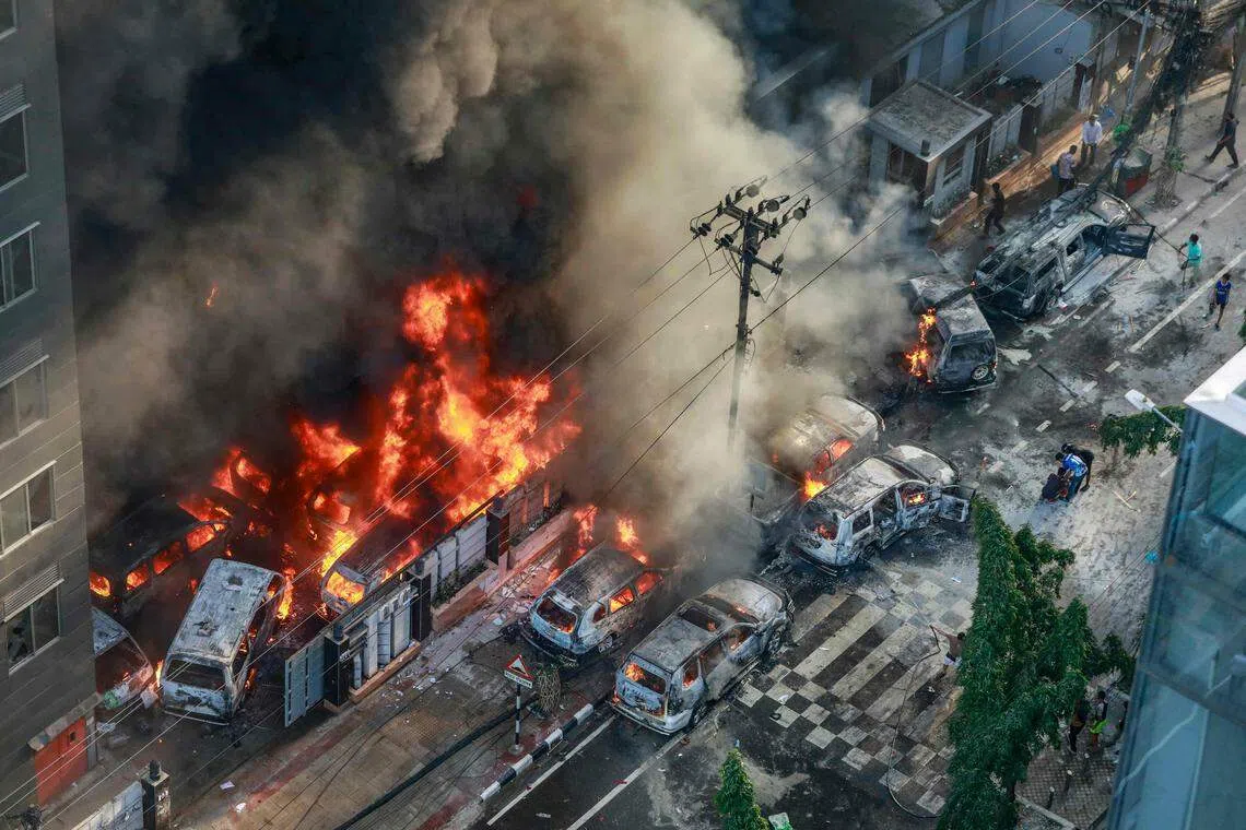 7月18日，抗议者在灾害管理局办公室附近放火，燃烧的车辆冒出浓烟。（法新社）