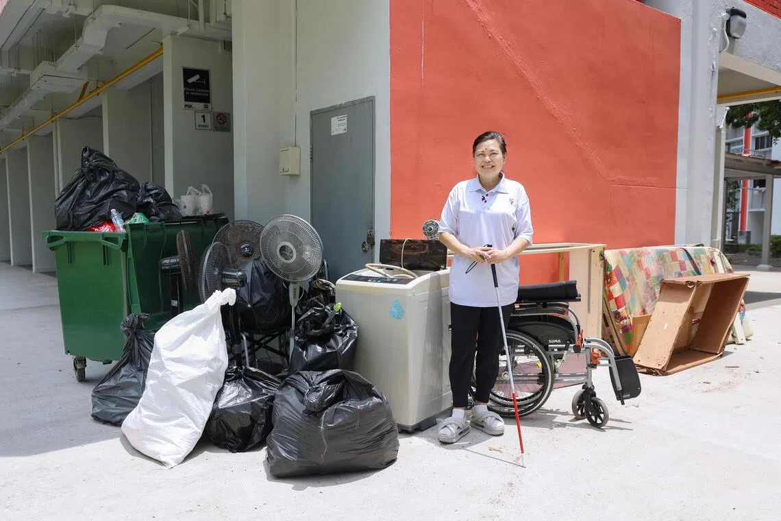 潘迎芬领着义工进入宏茂桥1道一个二房式租赁组屋单位，清理出大量垃圾，让原本脏乱的房子焕然一新。（游甯稀摄）