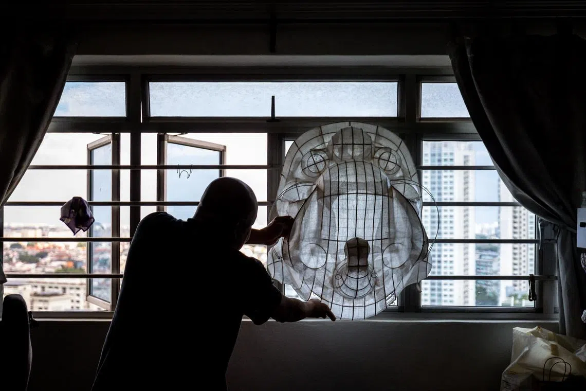 黄宏强把贴上浆糊的狮头骨架挂在窗口晾干。（叶振忠摄）