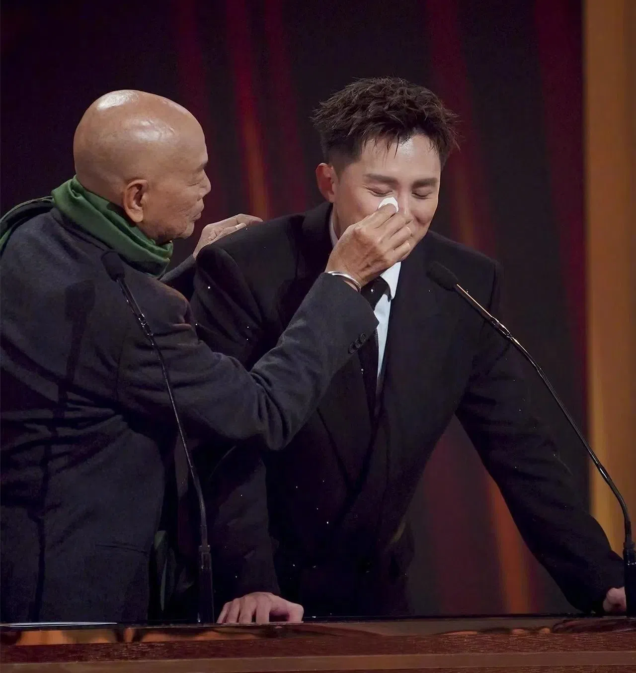 颁奖人罗家英（左）为何广沛拭泪。（互联网）