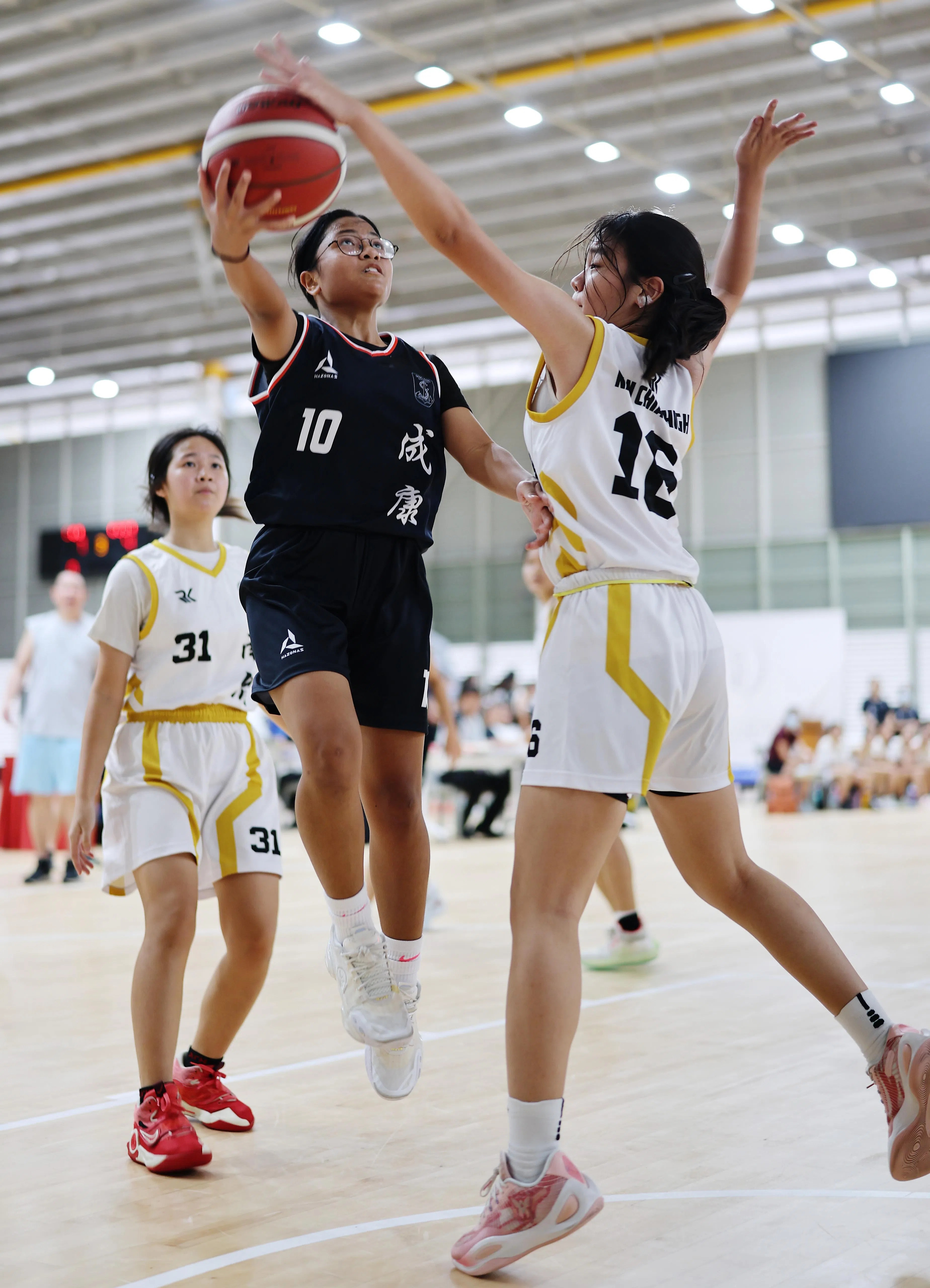 相机的高速连拍及预拍功能，帮助摄影师捕捉球员上篮的瞬间。（谢智扬摄）