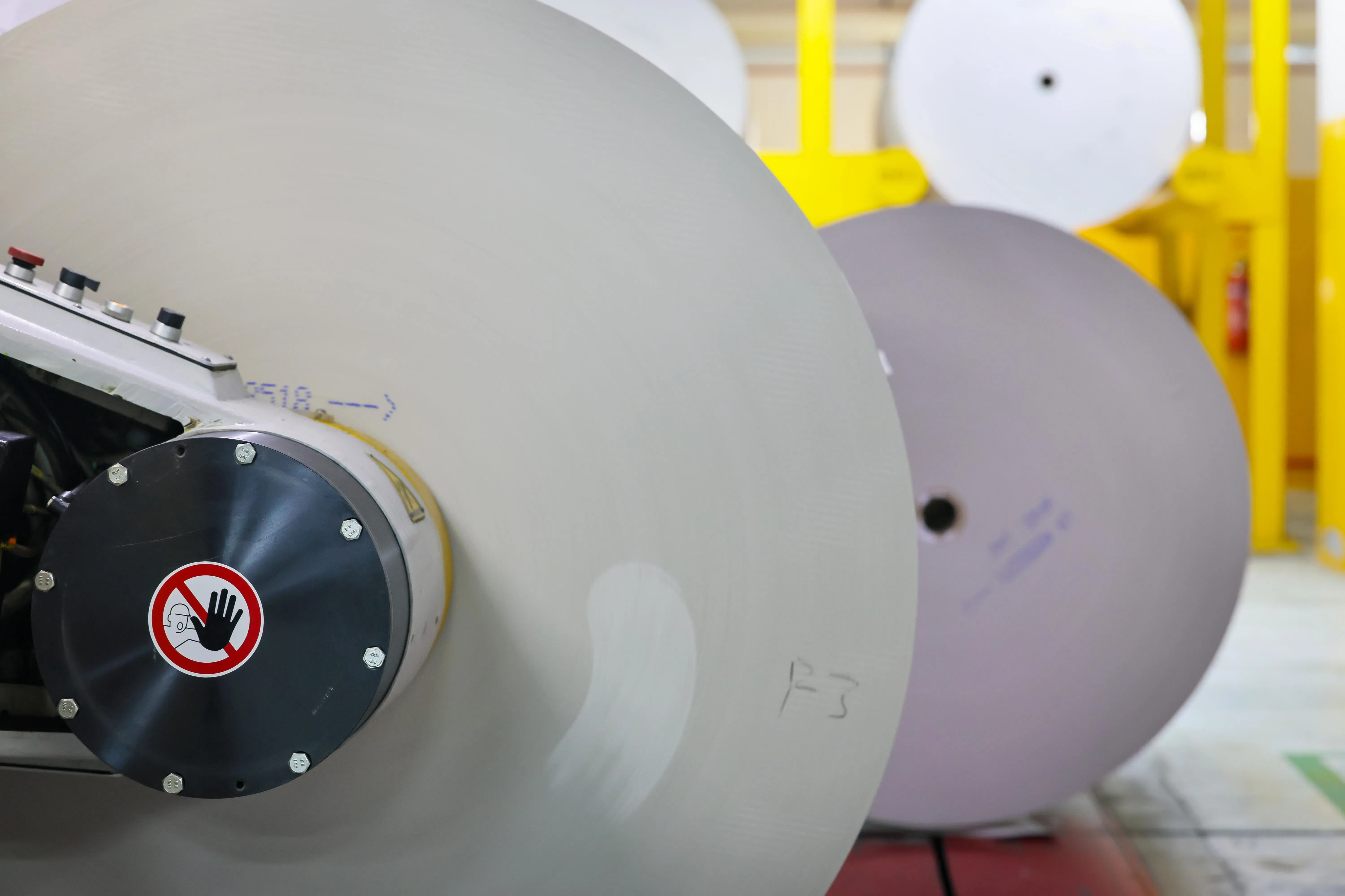 一筒筒重1441公斤，长2万2455米的印刷纸，在无人运输机器的引导下，“排队”进入印刷机。（龙国雄摄）