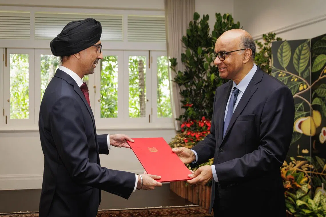 拉杰帕尔星（左）从尚达曼总统手中接过委任状。（数码发展及新闻部提供）