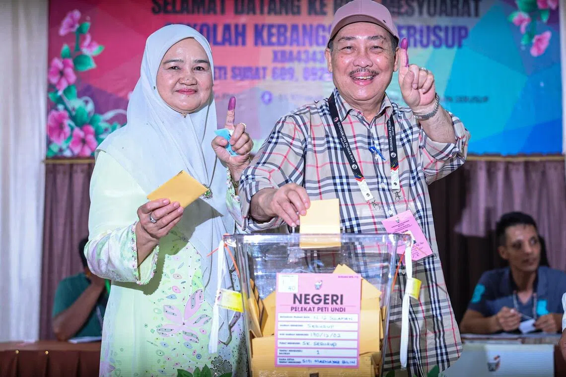 沙盟主席哈芝芝（右）预计蝉联沙巴首长职，消息称他会在正式成绩公布后很快宣誓就任。图为哈芝芝周六（11月29日）早上和妻子一同前往投票中心投票。（马新社）