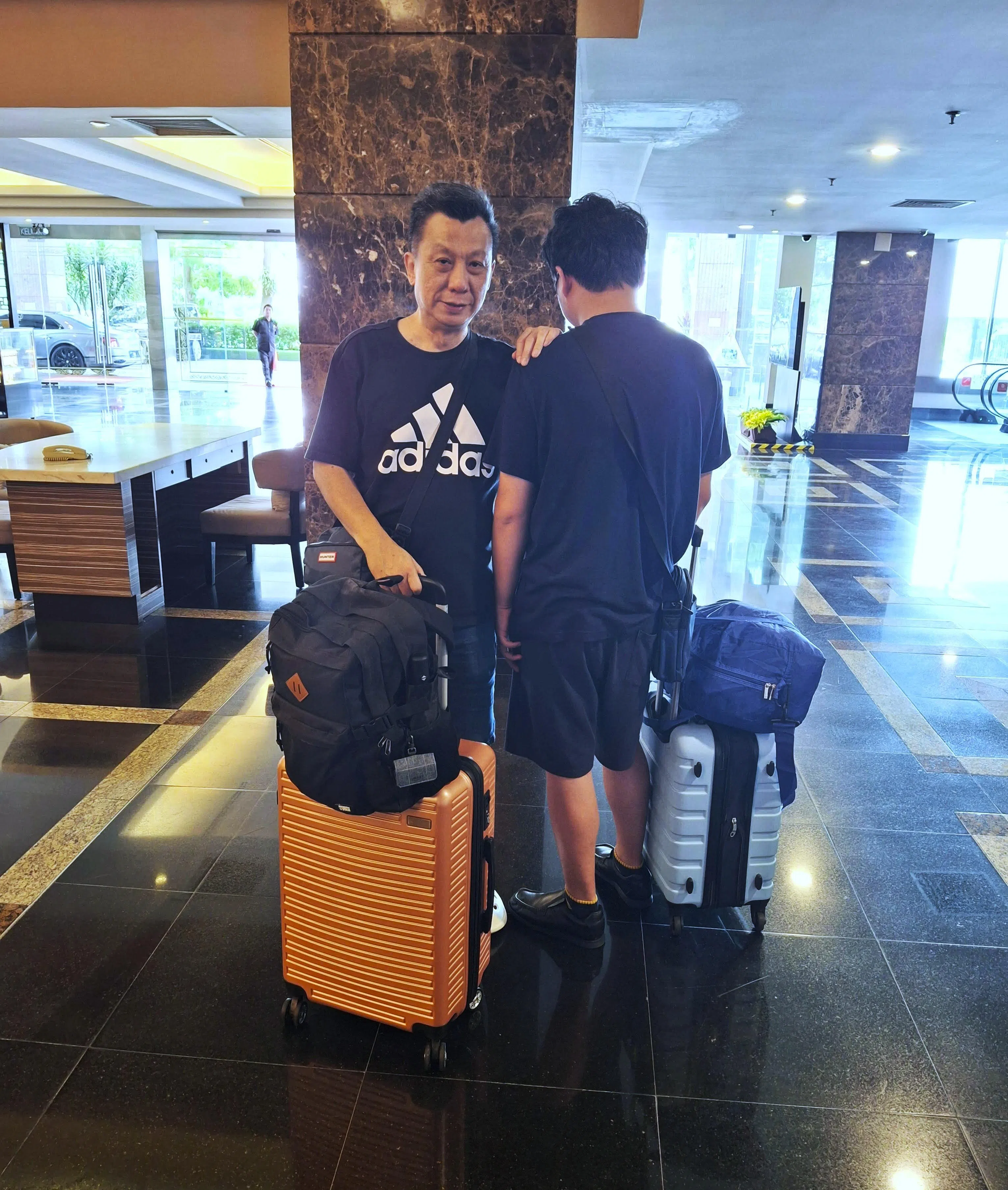 叶春贵和侄儿叶政霆（背对者）这两年以酒店和民宿为家，一个行李箱就是全副家当，两人也爱到大自然徒步。（受访者提供）