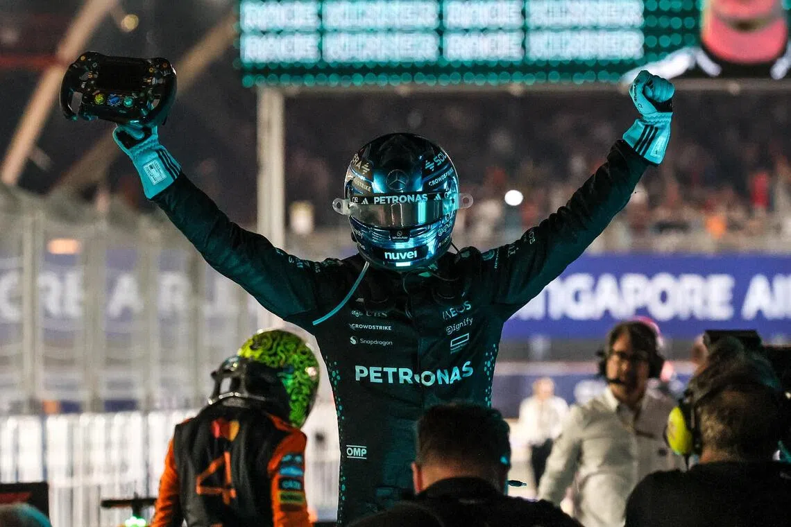 马赛地车手拉塞尔在夺冠后高举方向盘庆祝夺冠。（张俊杰摄）