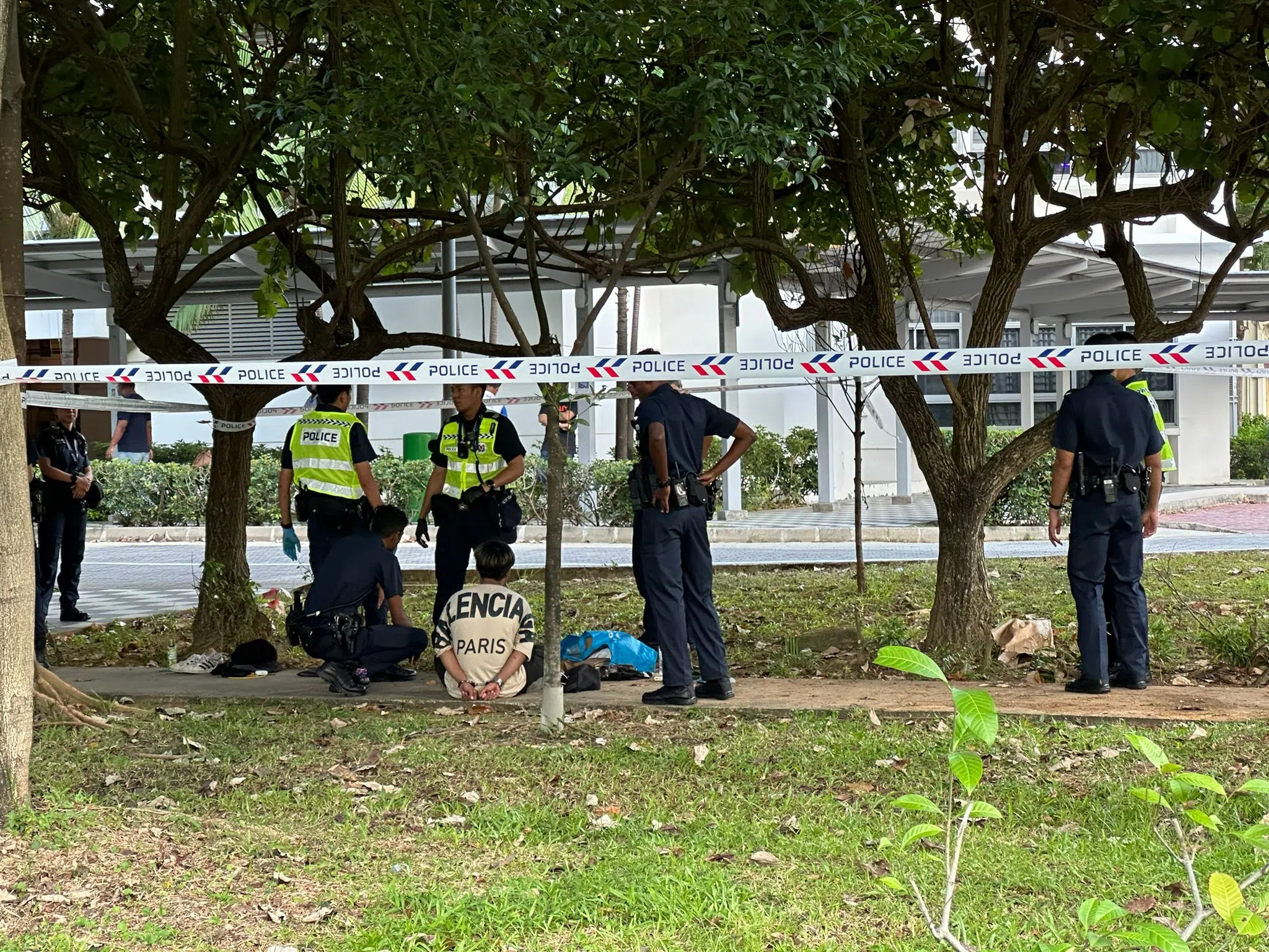 其中一名逃跑的年轻男子被警员带回车祸现场问话。（读者提供）
