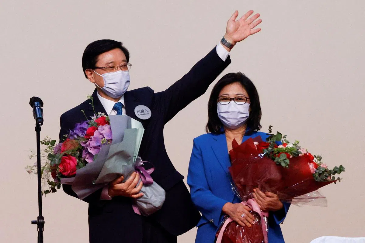 李家超在当选后，与妻子向支持者致谢。（路透社）