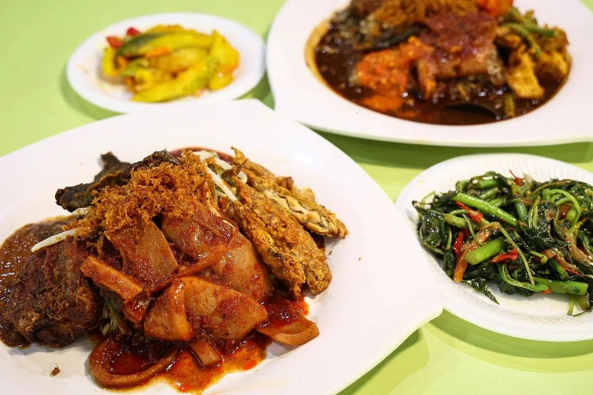 Gerai Nenek Obek售卖来自印尼泗水的花生酱汁饭Nasi Jenganan（前左）与牛肉黑汁饭Nasi Rawon（后右）。（李健玮摄）