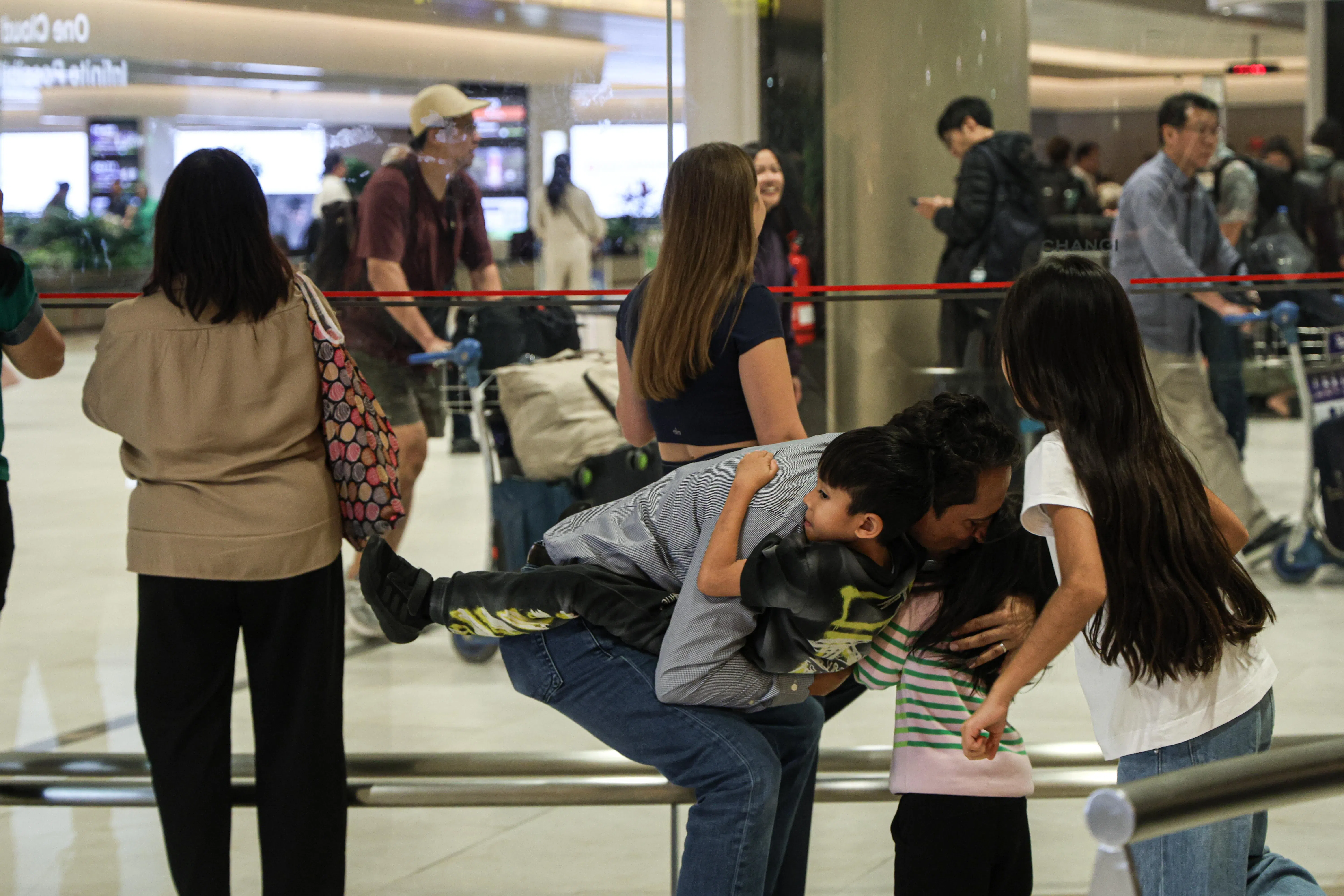 星期四晚上，搭乘阿提哈德航空EY498航班，从阿布扎抵达樟宜机场的新加坡人，看到接机的家人，激动地互相拥抱。（关俊威摄）