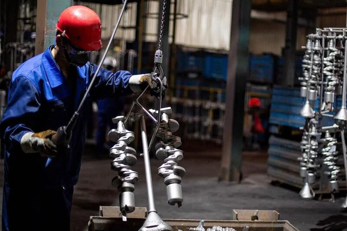 中国江苏省一家汽车零件制造厂的工人在工作。（法新社）