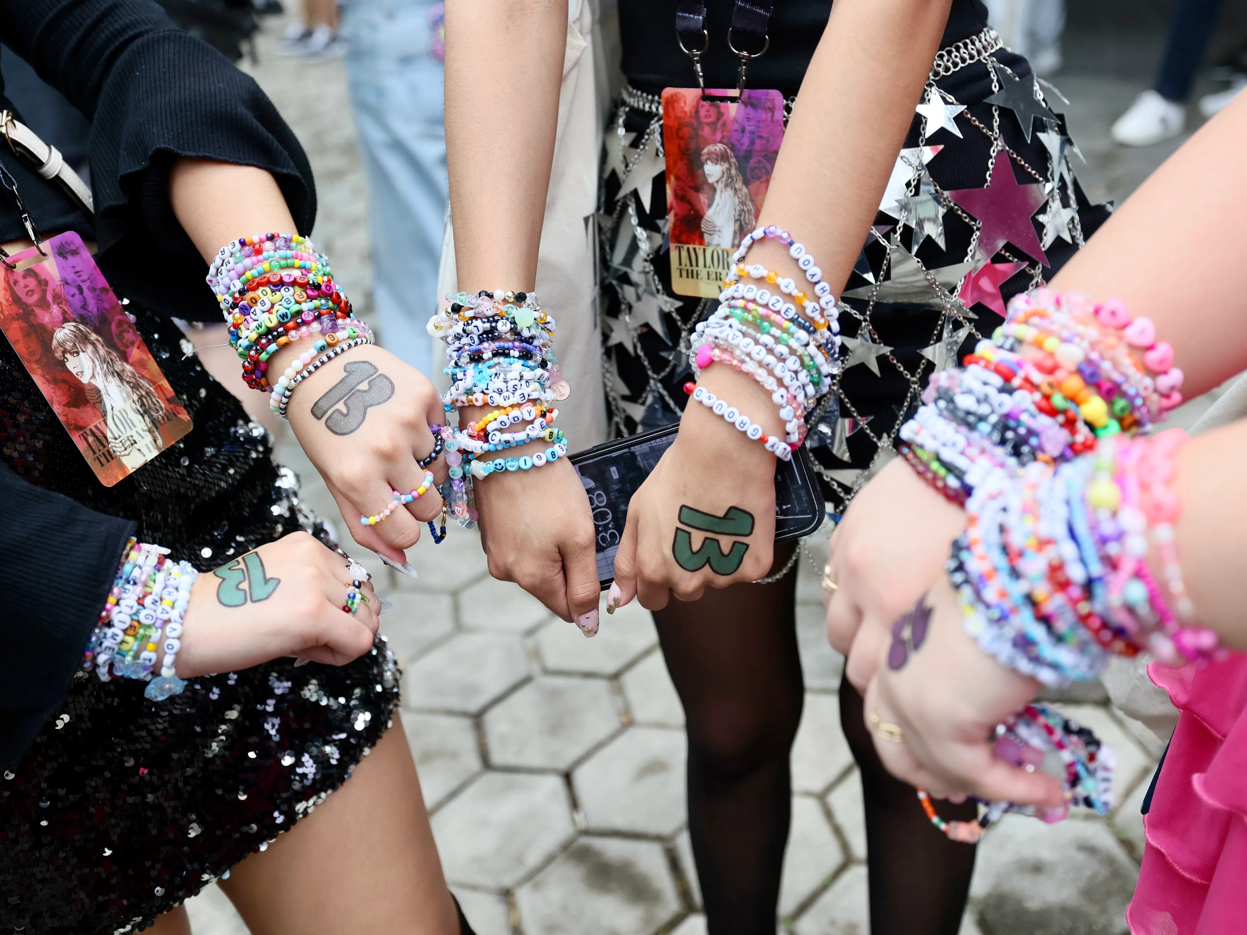 来听演唱会的歌迷戴着精心制作的友谊手链，还在手背上绘上泰勒丝的幸运数字“13”。（郑一鸣摄）