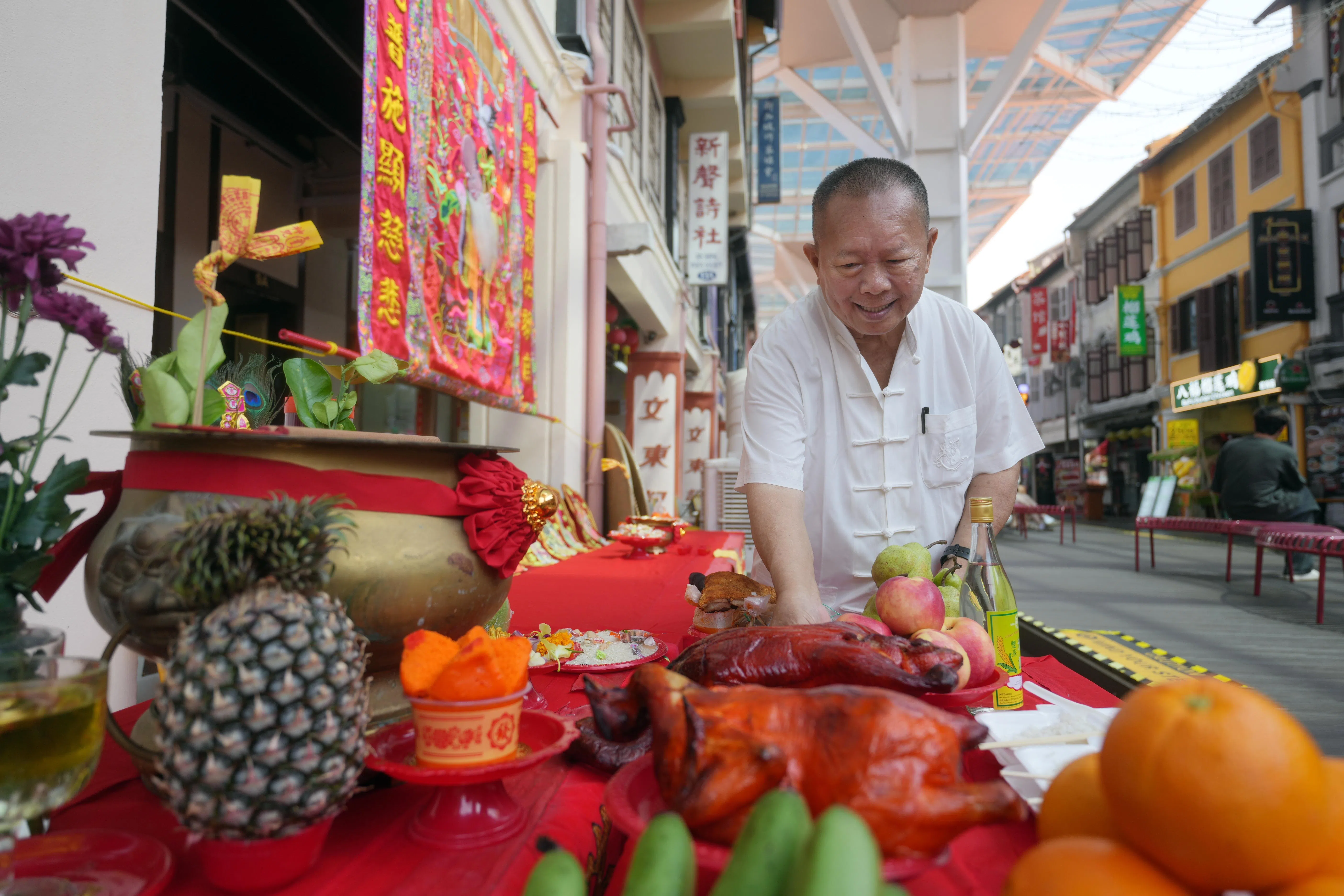 陆荣新师傅在祭拜前，帮忙布置祭坛。（谢智扬摄）