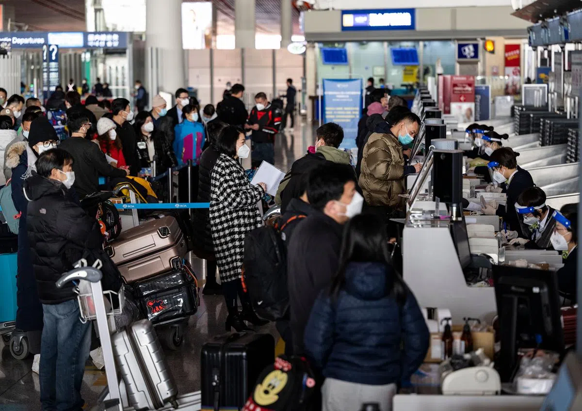 中国北京首都国际机场的日本航空公司柜台，在星期天（1月8日）出现了大批旅客排队等待办理登机手续。（中新社）