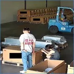 “公司1”内布置了数千台假服务器，以应对审计和检查。图为“仓库1”一名工作人员在处理包装箱外的序列号贴纸。（美国司法部官网）