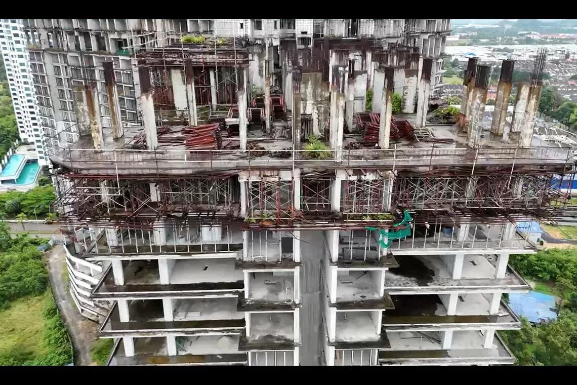 帝景湾尚未完工的建筑物久经风雨和日晒，部分地方已出现绿植生长。（视频截图）