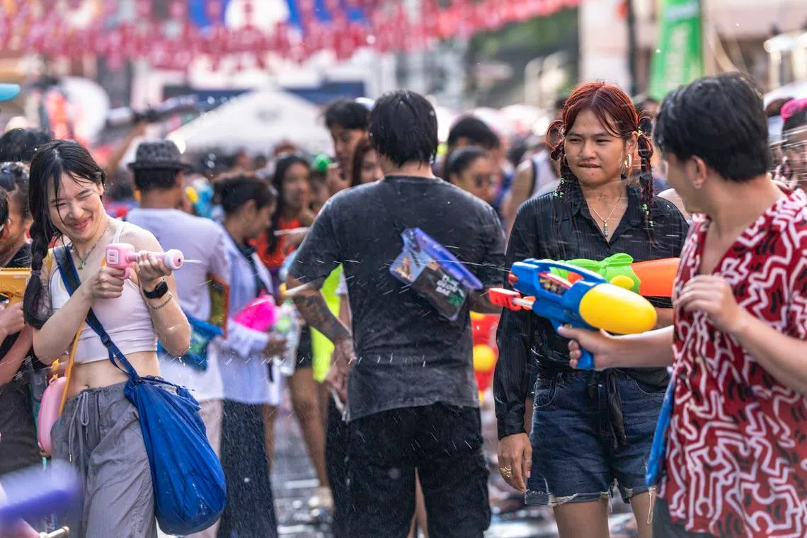 成人打水战，重拾儿时乐趣。（蔡光发摄）