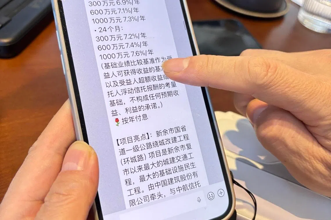 一名投资者1月13日在上海向记者展示中航信托投资顾问发来的产品信息。（黎康摄）