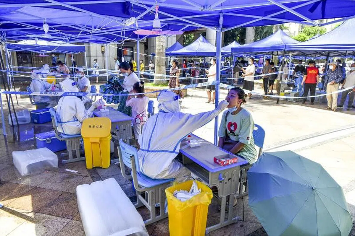 今年以来，动辄几星期甚至逾一个月的“静态管理”，以及其他封控导致的次生灾害，都使民众愈发质疑“不惜一切代价”管控疫情是否值得。图为海南省海口市进入封控前一天（8月7日）的核酸检测现场。（中新社）