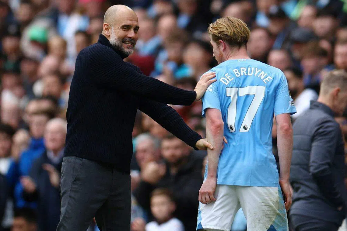 曼市上轮联赛大胜卢顿后夺回榜首，主帅瓜迪奥拉（左）能否再接再厉，连续两个赛季与中场大将德布吕纳创下三冠王成就？（路透社）